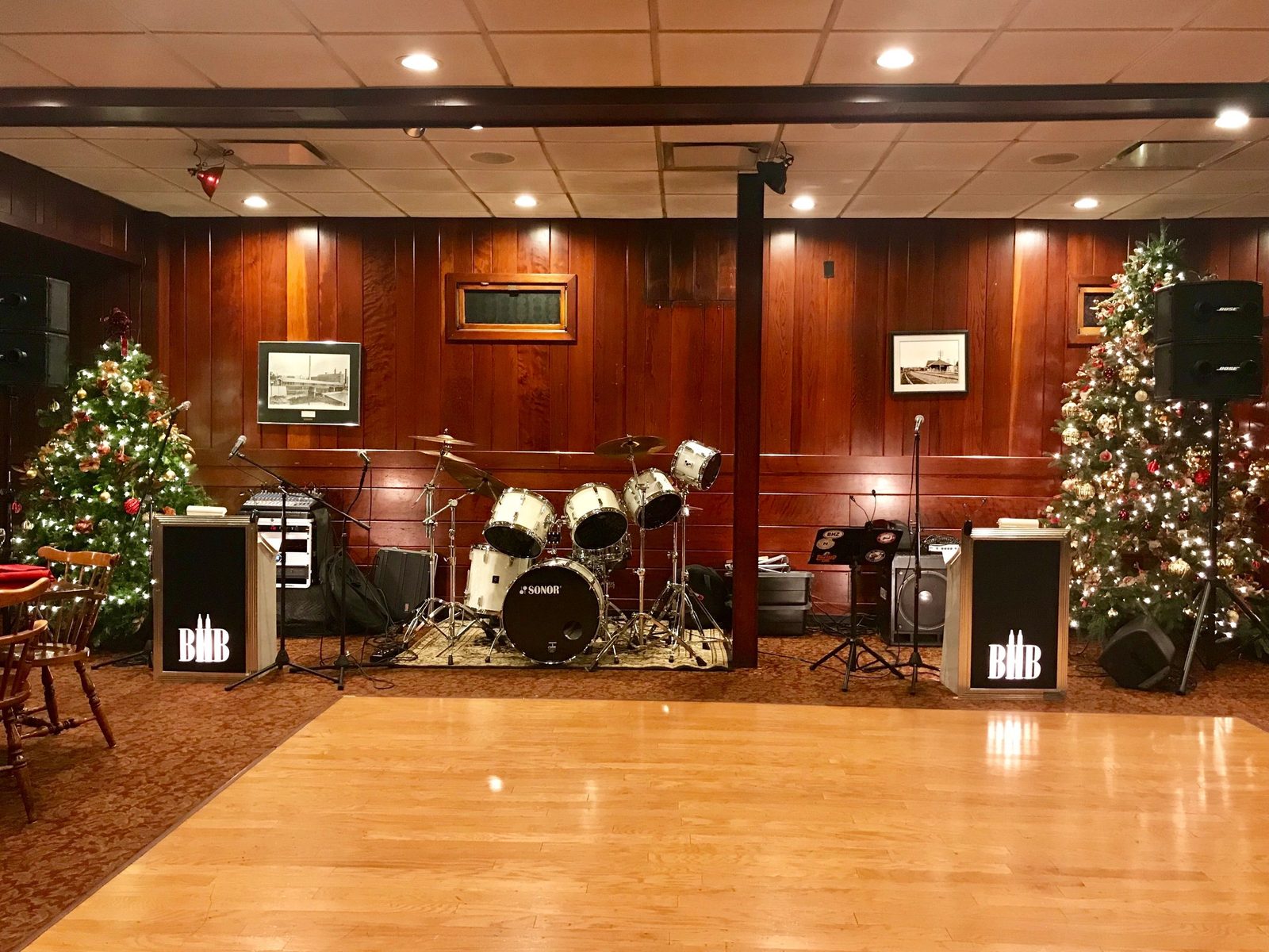 Holiday party stage with drum kit, BHB monitors, and Christmas trees