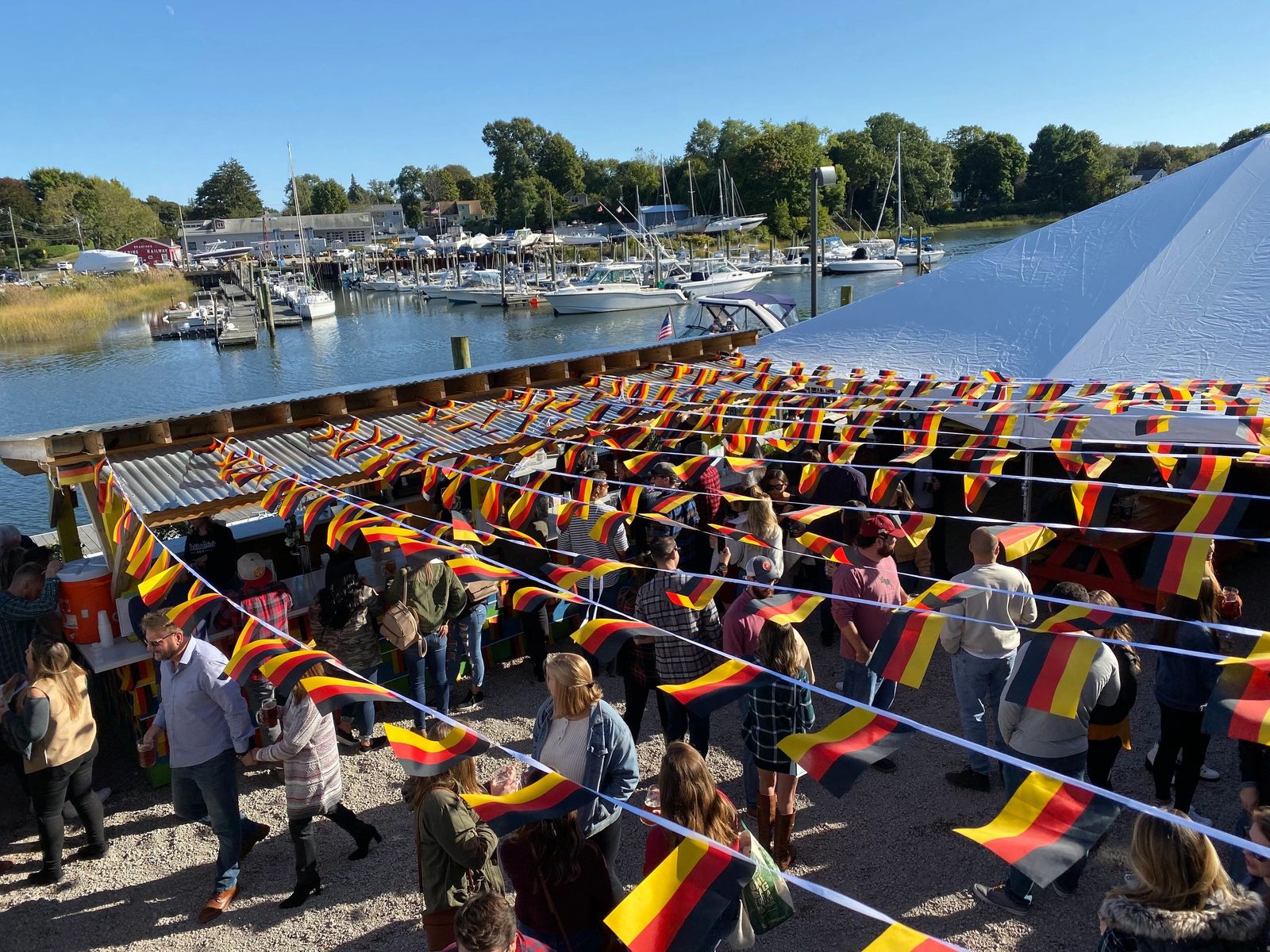 Harbor-side Oktoberfest crowd with black-red-gold bunting